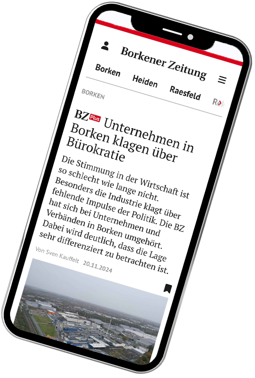 Ein Smartphone zeigt einen Artikel der Borkener Zeitung mit dem Titel „Unternehmen in Borken klagen über Bürokratie“ und einem Bild, das eine Industrie- oder Gewerbefläche aus der Vogelperspektive zeigt.